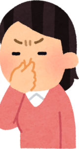 鼻を指でつまむ女性