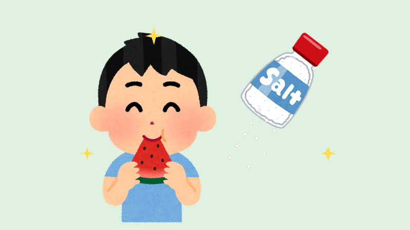 スイカに塩をふって食べる少年