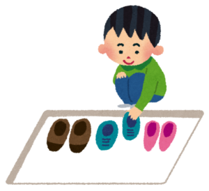 玄関で靴を揃える子ども